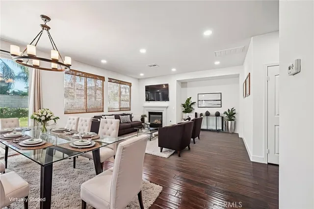 a living room with furniture a large window and wooden floor