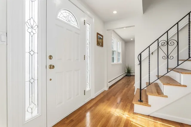 a view of a hallway with entryway wooden floor and front door