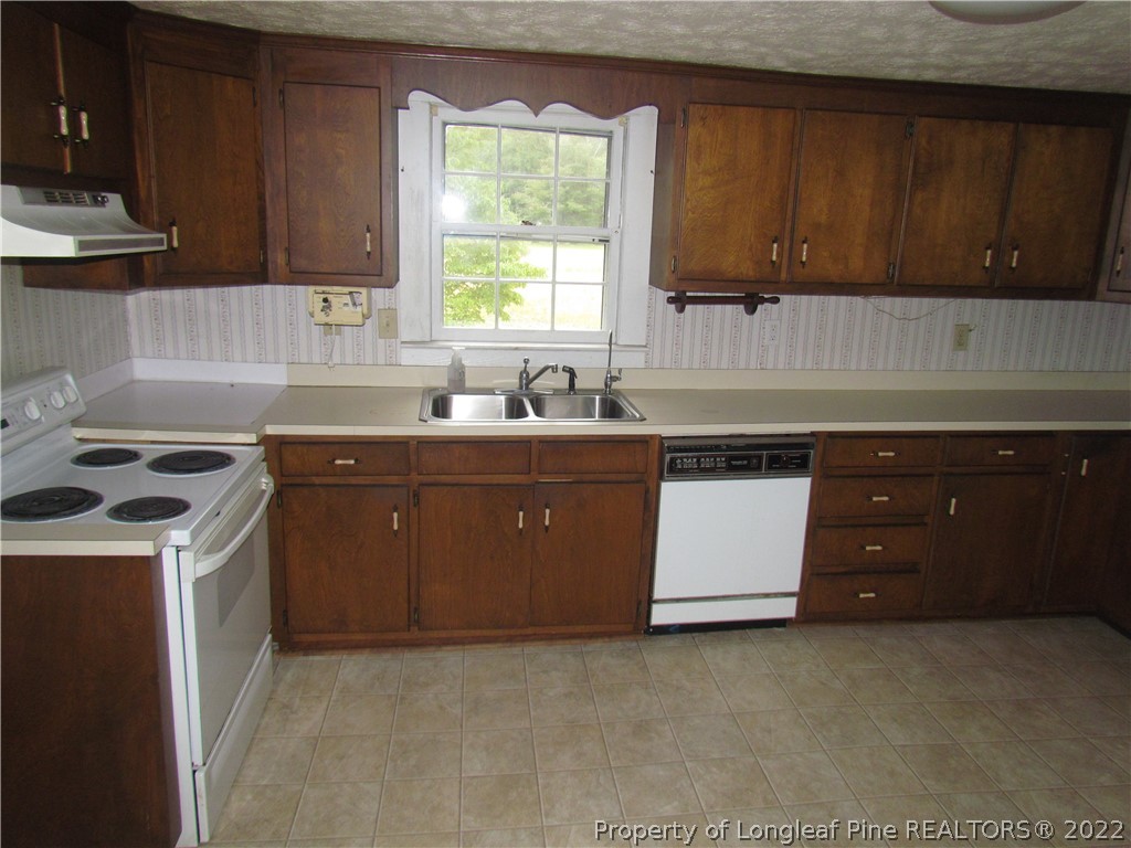 1635 Wade-Stedman Road Stedman, NC 28391 - Photo 7 of 23 a kitchen with a sink a stove and cabinets