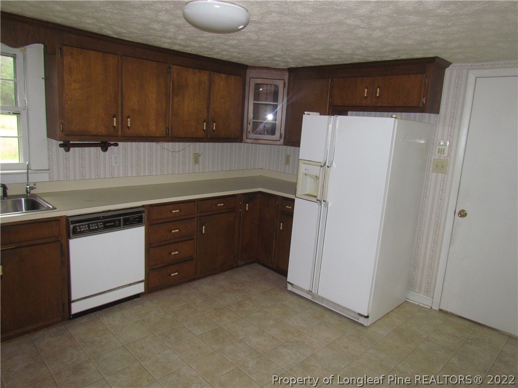 1635 Wade-Stedman Road Stedman, NC 28391 - Photo 8 of 23 a kitchen with granite countertop a refrigerator and a sink