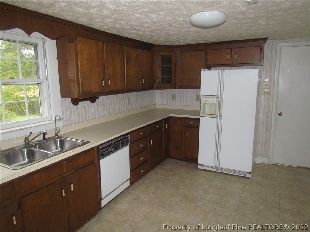 1635 Wade-Stedman Road Stedman, NC 28391 - Photo 9 of 23 a kitchen with stainless steel appliances granite countertop a sink stove and refrigerator