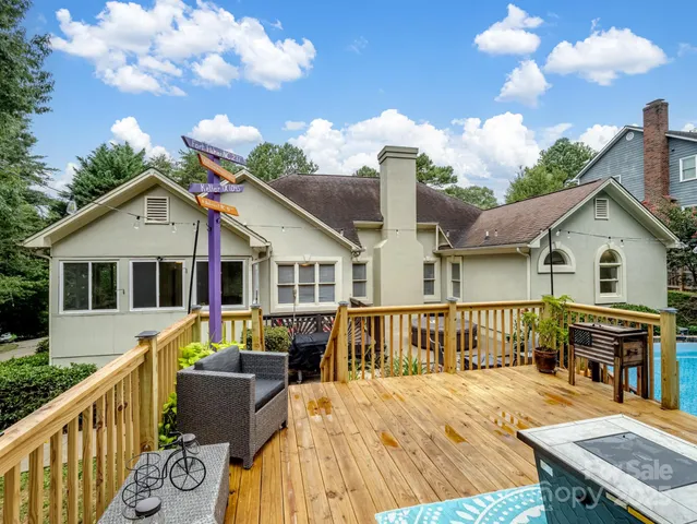 a view of a house with wooden deck and furniture