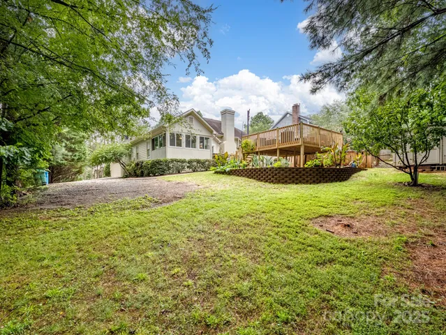 a view of a big house with a big yard and large trees
