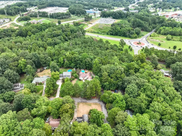 an aerial view of residential house with outdoor space and trees all around