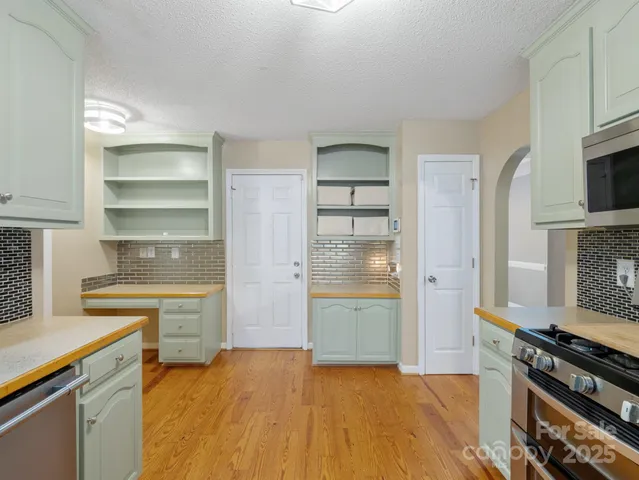 a kitchen with a refrigerator and a stove top oven