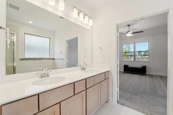 a en suite bathroom with a double vanity sink and a mirror