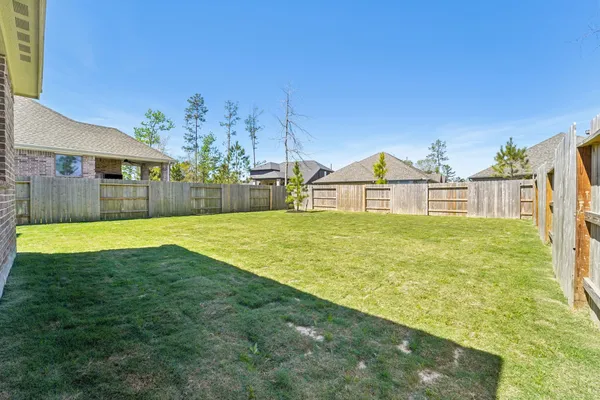 a view of a swimming pool with a lawn chairs and a small yard