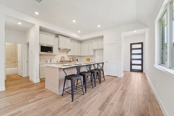 a open kitchen with white cabinets and stainless steel appliances