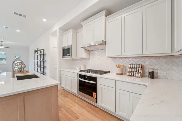 a kitchen with granite countertop white cabinets and white appliances