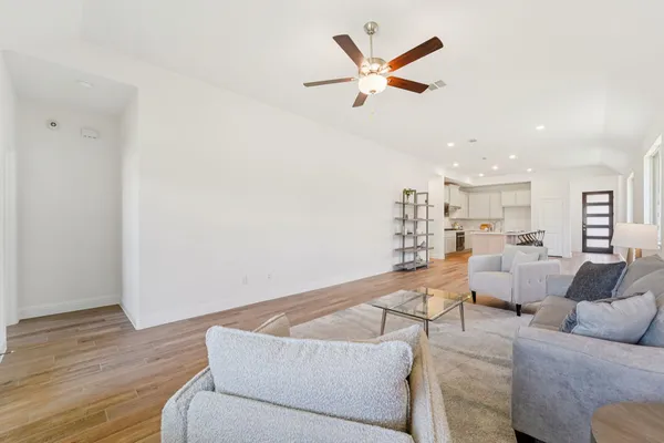 a living room with furniture and a wooden floor