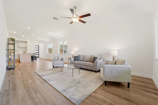 a living room with furniture and a wooden floor