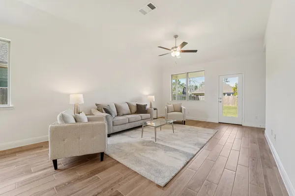 a living room with furniture and wooden floor