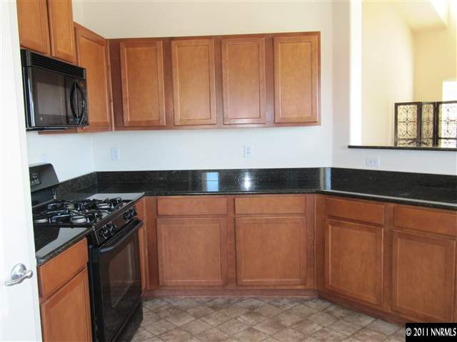 9050 Double R Boulevard Reno, NV 89511 - Photo 3 of 13 a kitchen with stainless steel appliances granite countertop a stove a sink and a microwave