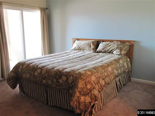 9050 Double R Boulevard Reno, NV 89511 - Photo 8 of 13 a bedroom with a bed and window
