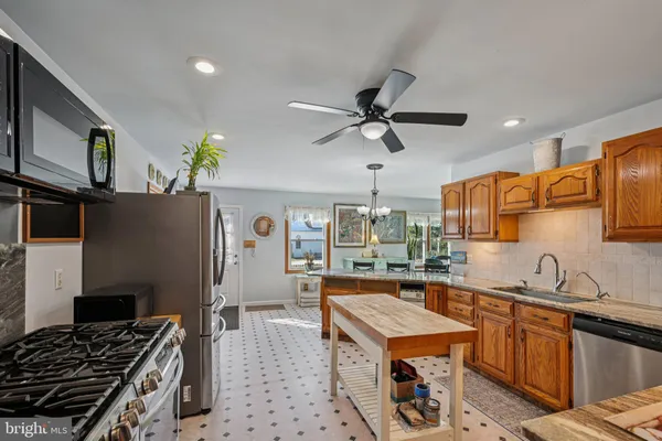 a kitchen with stainless steel appliances granite countertop a sink a stove and a refrigerator