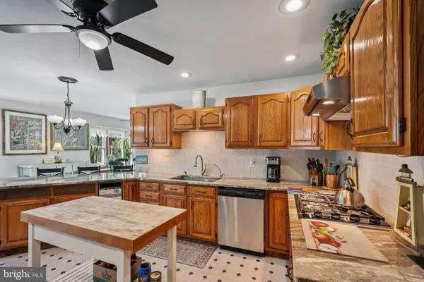 a kitchen with stainless steel appliances kitchen island granite countertop a dining table and chairs