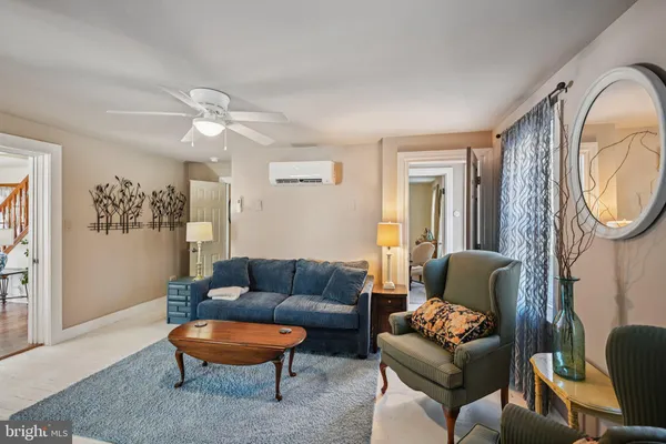 a living room with furniture a flat screen tv and a window