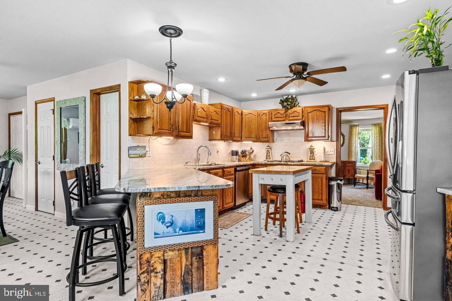 668 Crawford Road Cape May, NJ 08204 - Photo 22 of 66 a kitchen with stainless steel appliances kitchen island granite countertop a refrigerator a stove a sink a dining table and chairs with wooden floor