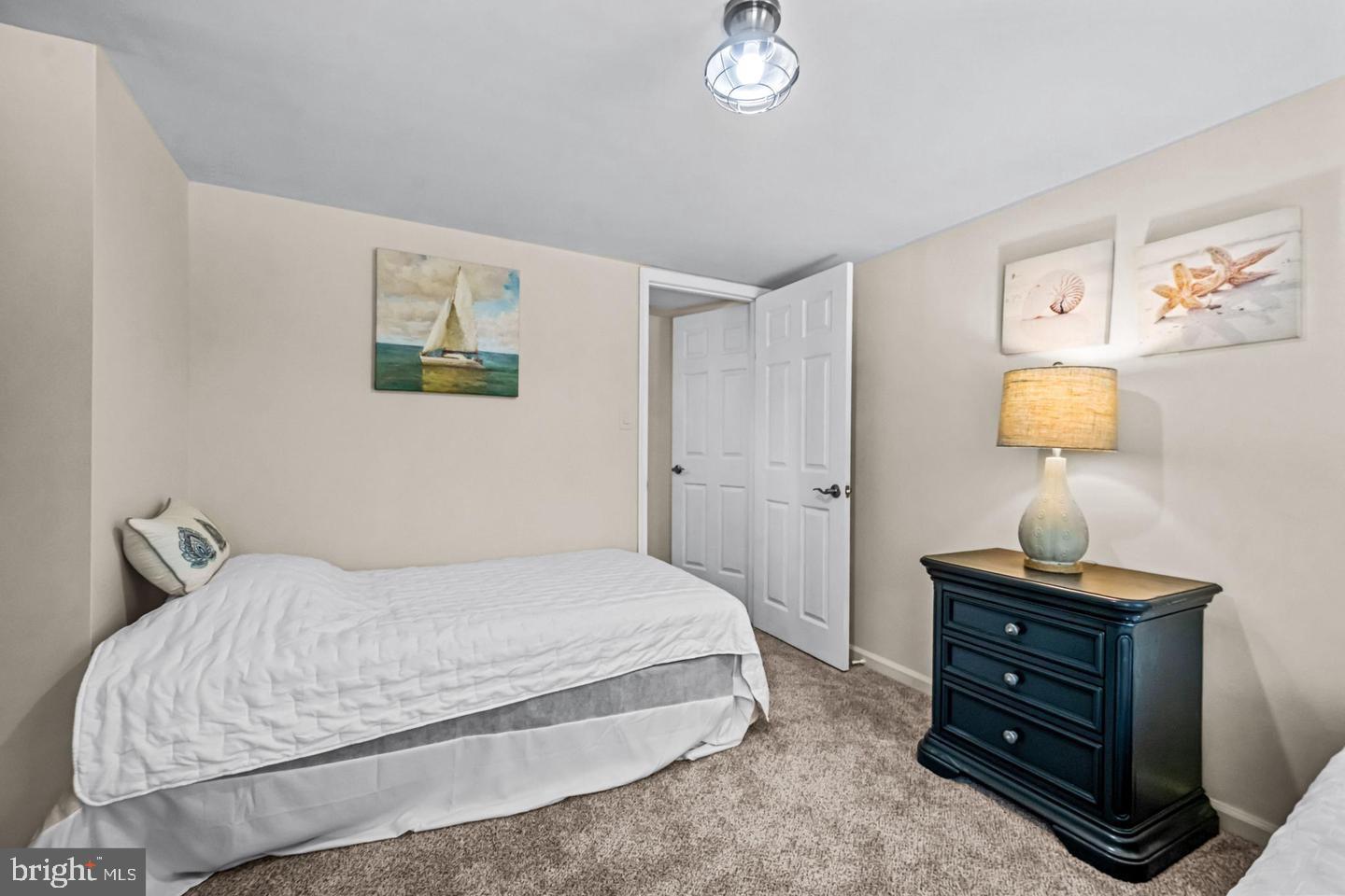 668 Crawford Road Cape May, NJ 08204 - Photo 44 of 66 a bedroom with a bed and a lamp on dresser