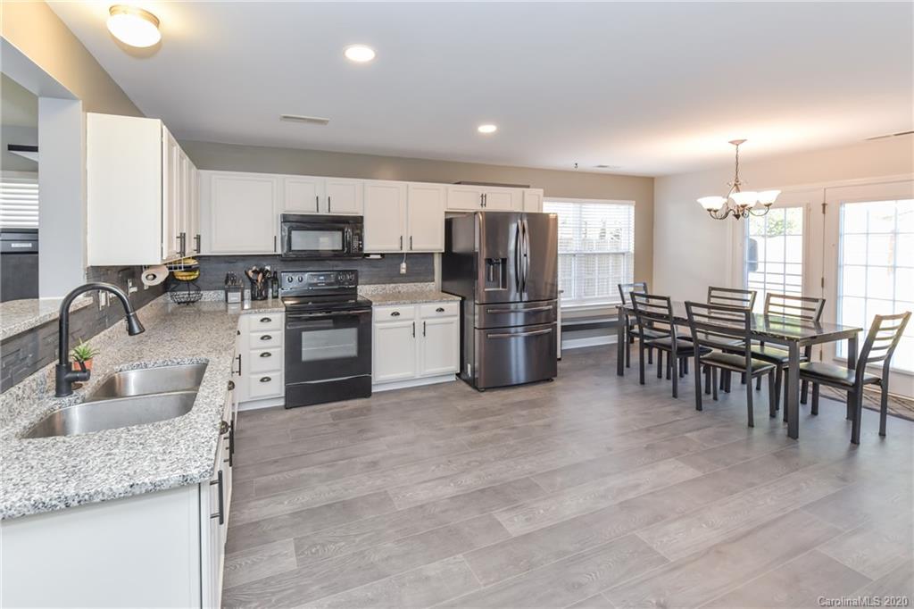 717 Jones Branch Road Fort Mill, SC 29715 - Photo 8 of 31 a kitchen with stainless steel appliances granite countertop a stove top oven a sink a dining table and chairs