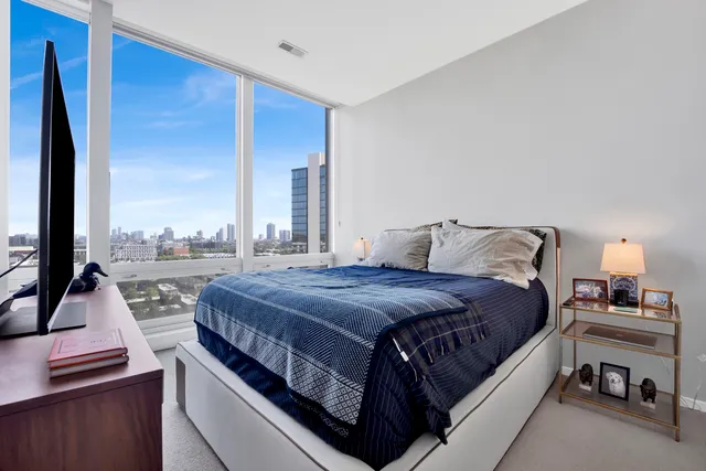 a bedroom with a bed and large window