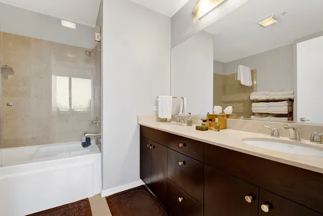 a bathroom with a tub sink and mirror