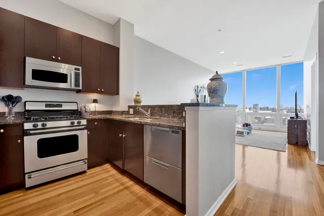 a kitchen with stainless steel appliances kitchen island granite countertop a stove a sink and a microwave