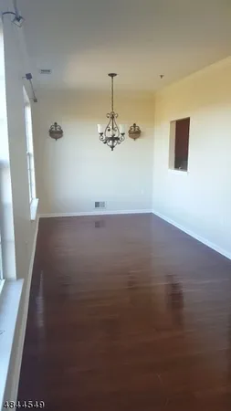 a view of a room with wooden floor and chandelier