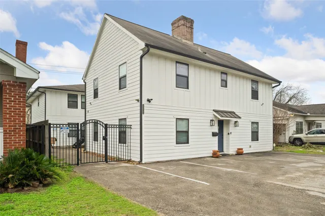 a view of a white house with a yard and plants