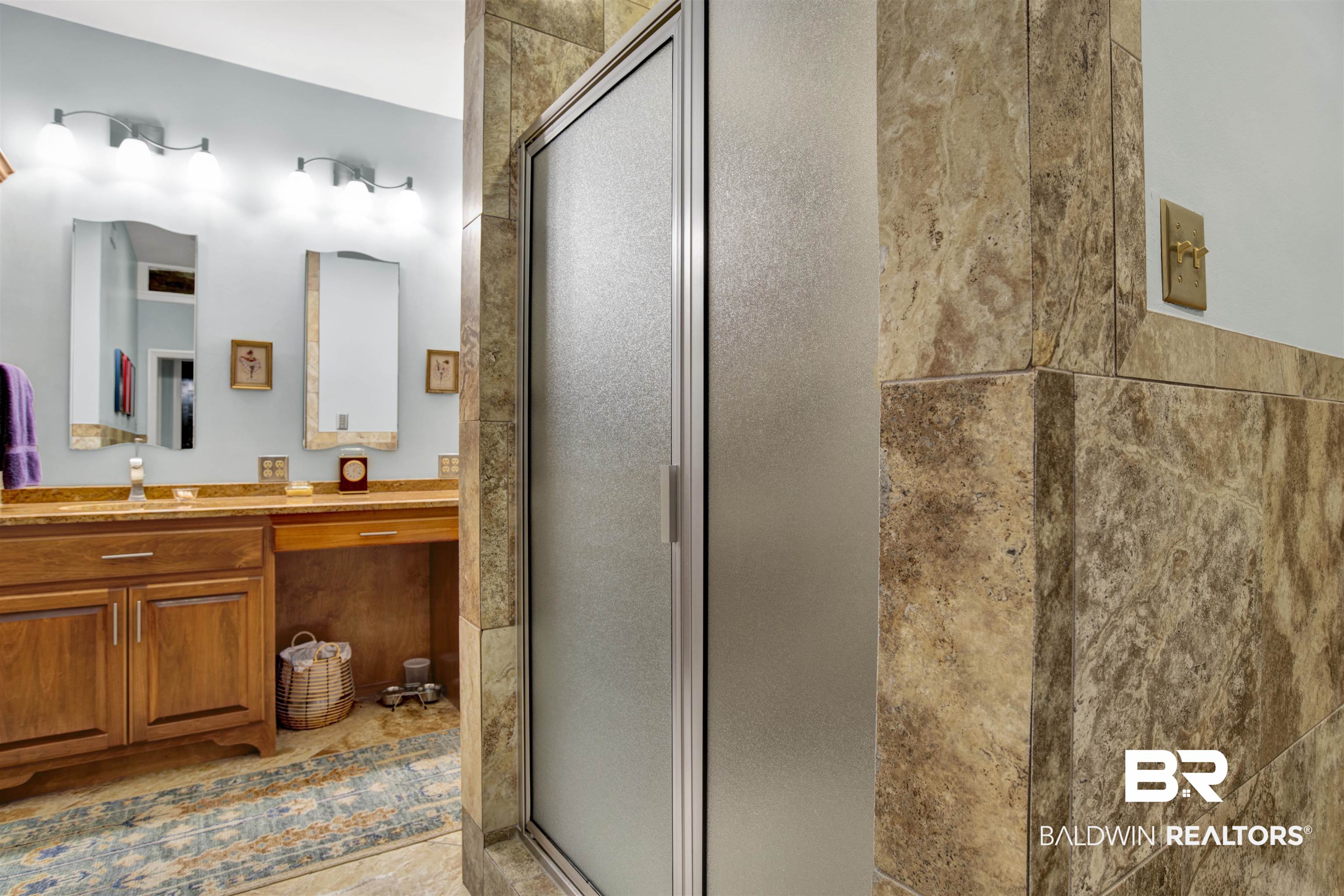 809 Bernard Circle Mobile, AL 36693 - Photo 23 of 75 Bathroom featuring a tiled shower enclosure with a frosted glass door, dual wood-finish vanities with undermount sinks, and stone countertops