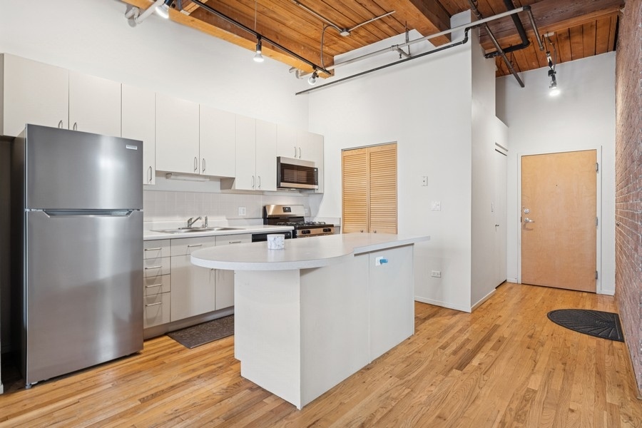 420 South Clinton Street, Unit 614A Chicago, IL 60607 - Photo 3 of 10 a kitchen with a refrigerator and a sink
