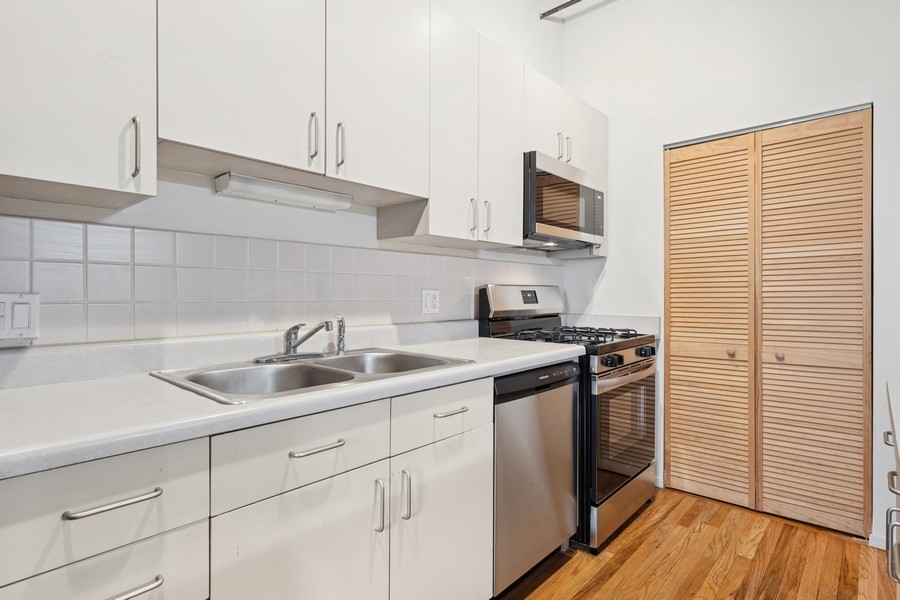 420 South Clinton Street, Unit 614A Chicago, IL 60607 - Photo 4 of 10 a kitchen with stainless steel appliances granite countertop a sink stove and refrigerator