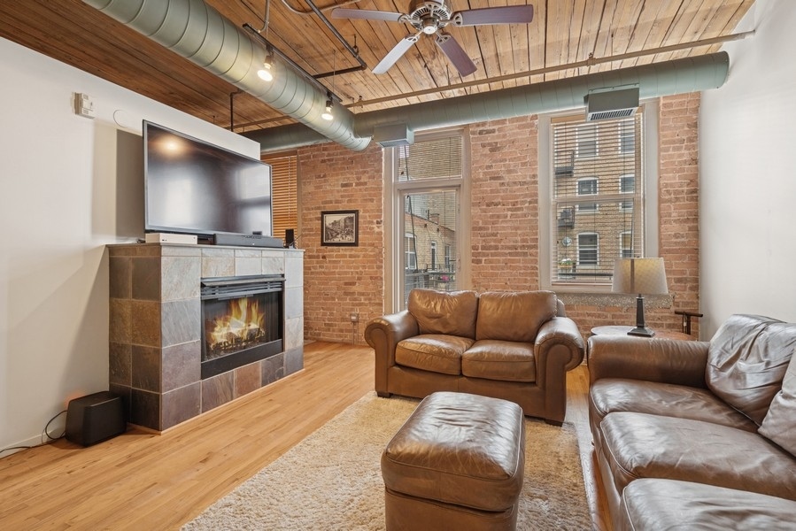 420 South Clinton Street, Unit 614A Chicago, IL 60607 - Photo 5 of 10 a living room with furniture a flat screen tv and a fireplace