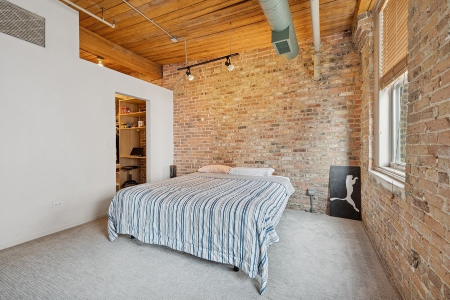 420 South Clinton Street, Unit 614A Chicago, IL 60607 - Photo 6 of 10 a bedroom with a bed and a walk in closet