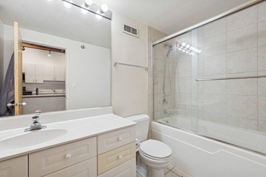 420 South Clinton Street, Unit 614A Chicago, IL 60607 - Photo 7 of 10 a bathroom with a granite countertop sink a toilet and shower