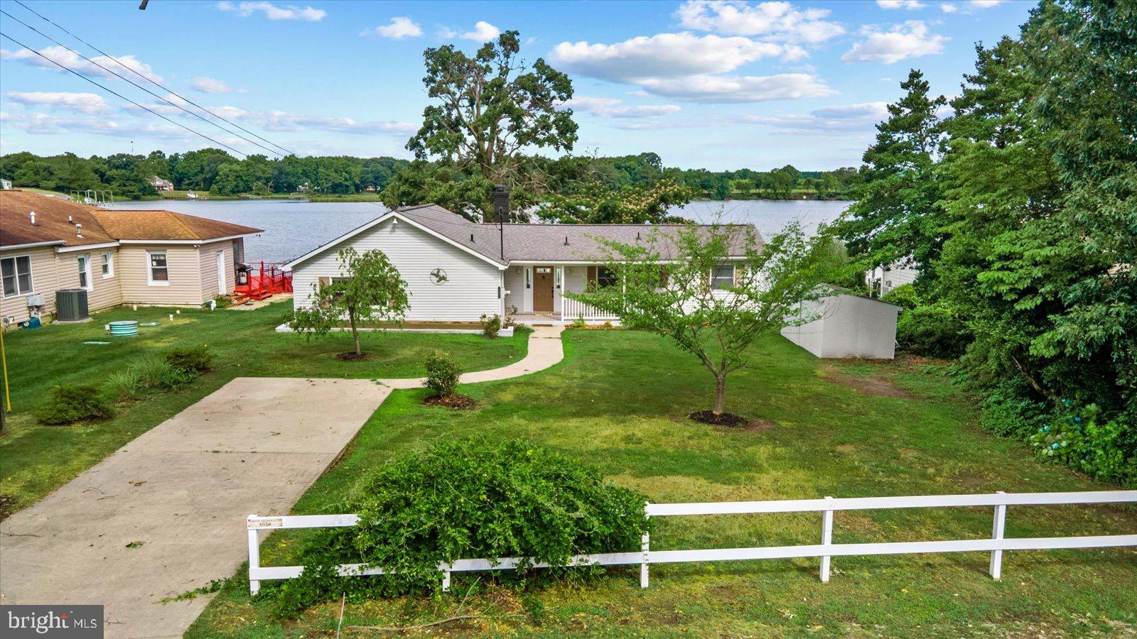 a view of a house with a yard and a large tree