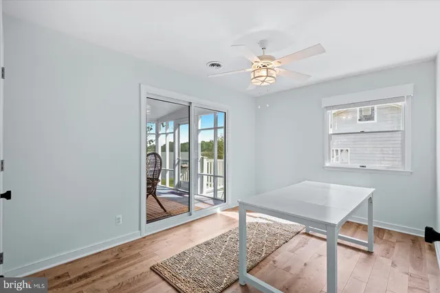 a view of a livingroom with wooden floor and a ceiling fan