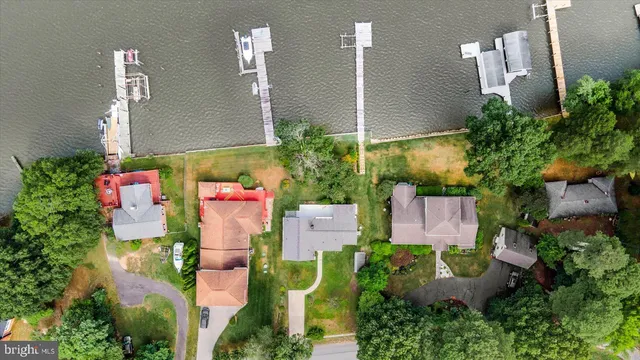 an aerial view of a house with a yard and lake view
