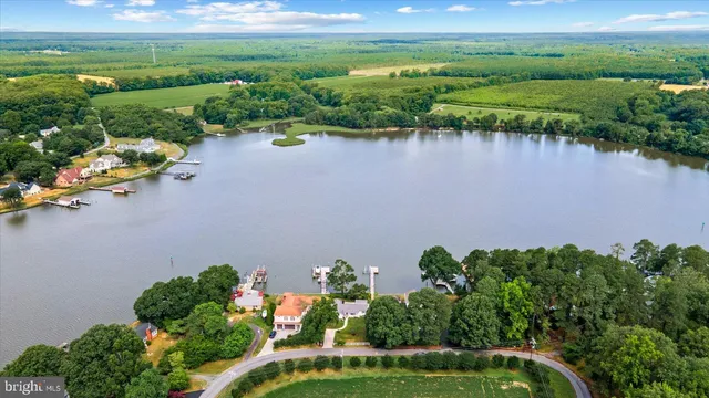 an aerial view of a house with a yard and lake view