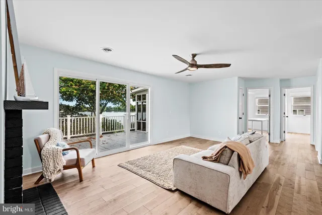 a living room with furniture a ceiling fan and a large window