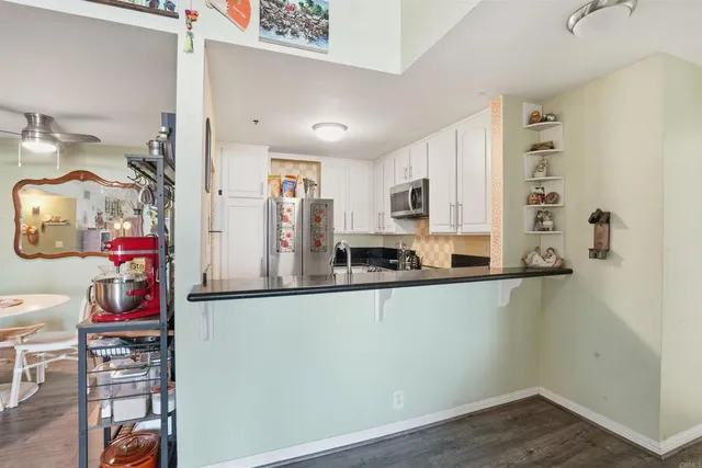 a kitchen with stainless steel appliances granite countertop a refrigerator and a stove top oven