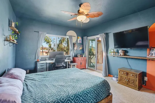 a bedroom with a bed and a flat tv screen on dresser
