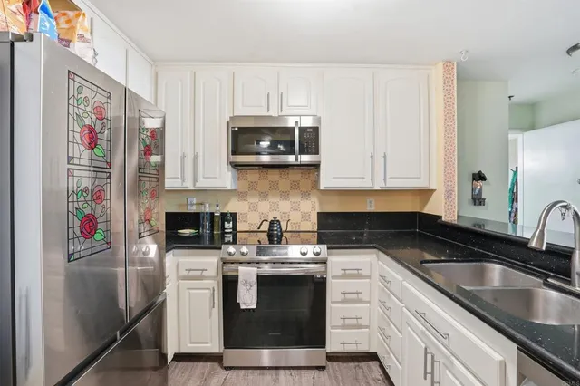 a kitchen with stainless steel appliances granite countertop a sink stove and microwave