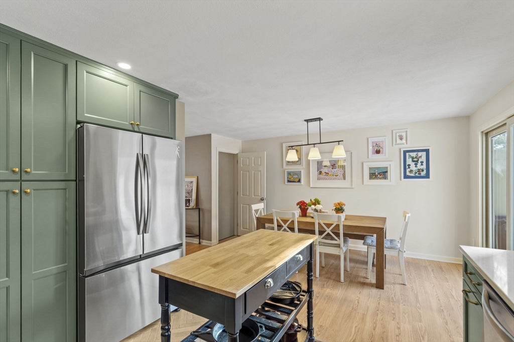 4 Apple Ridge Road, Unit 6 Maynard, MA 01754 - Photo 4 of 40 a kitchen with stainless steel appliances refrigerator dining table and chairs