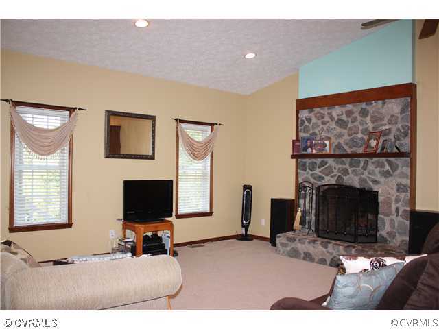 7307 Drexelbrook Road Chesterfield, VA 23832 - Photo 8 of 10 a living room with furniture a fireplace and a flat screen tv