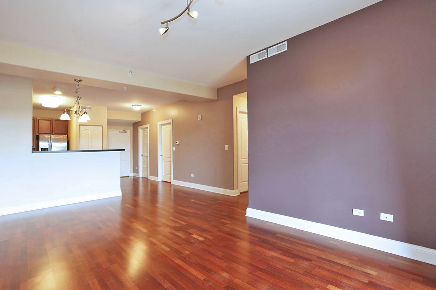 1 Itasca Place, Unit 304 Addison, IL 60143 - Photo 7 of 25 a view of an empty room with wooden floor and a kitchen