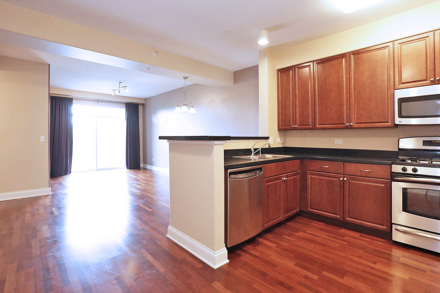 1 Itasca Place, Unit 304 Addison, IL 60143 - Photo 9 of 25 a kitchen with granite countertop wooden floors and stainless steel appliances