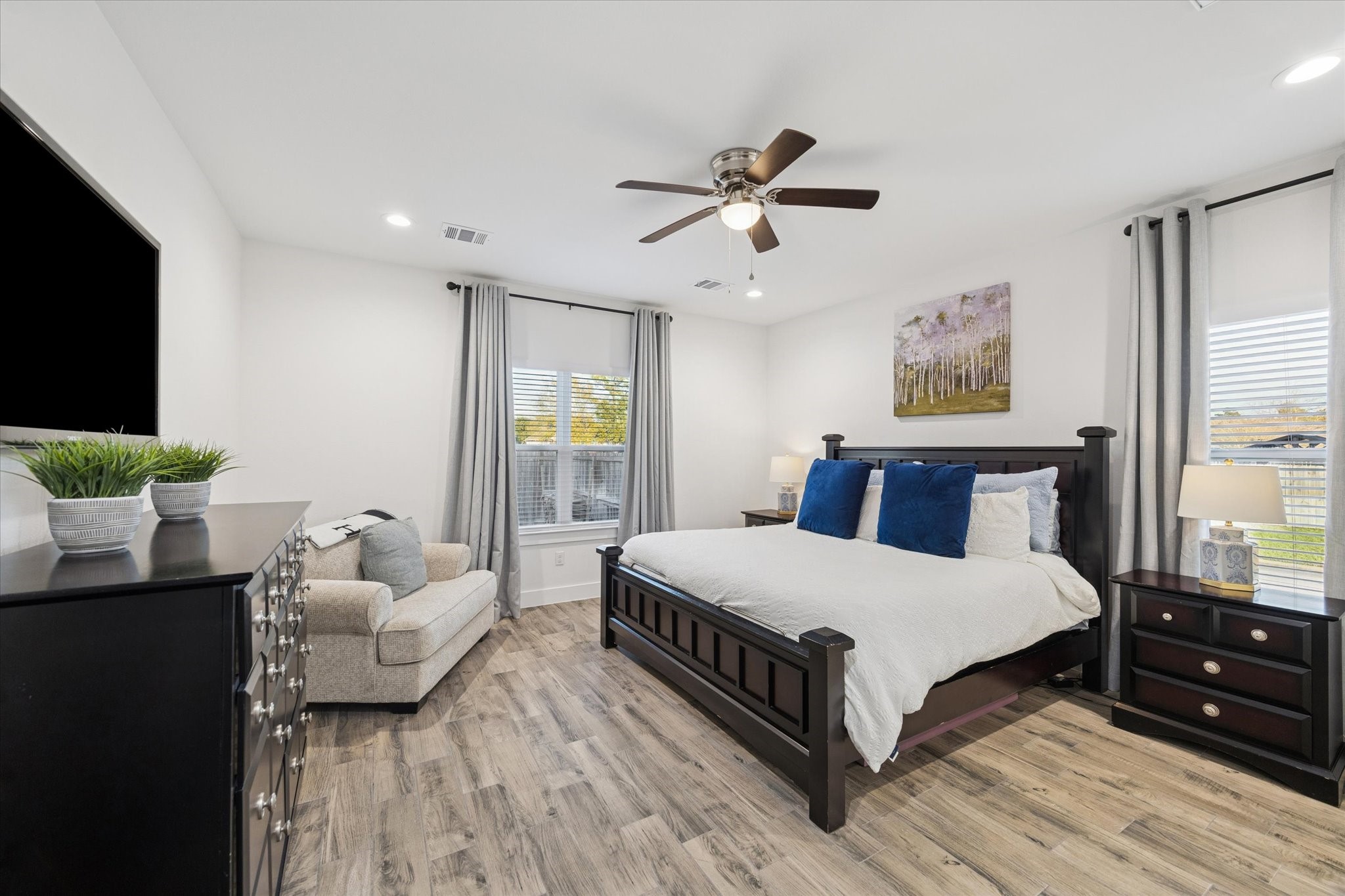 203 Hampton Glen Road Montgomery, TX 77356 - Photo 13 of 28 This view of the primary bedroom highlights an elegant, light-filled space. Spacious enough to accommodate all your bedroom furniture, it creates a serene retreat for rest and relaxation. The soft, light wall tones enhance the sense of calm and openness, while energy-efficient LED lighting adds both functionality and convenience.