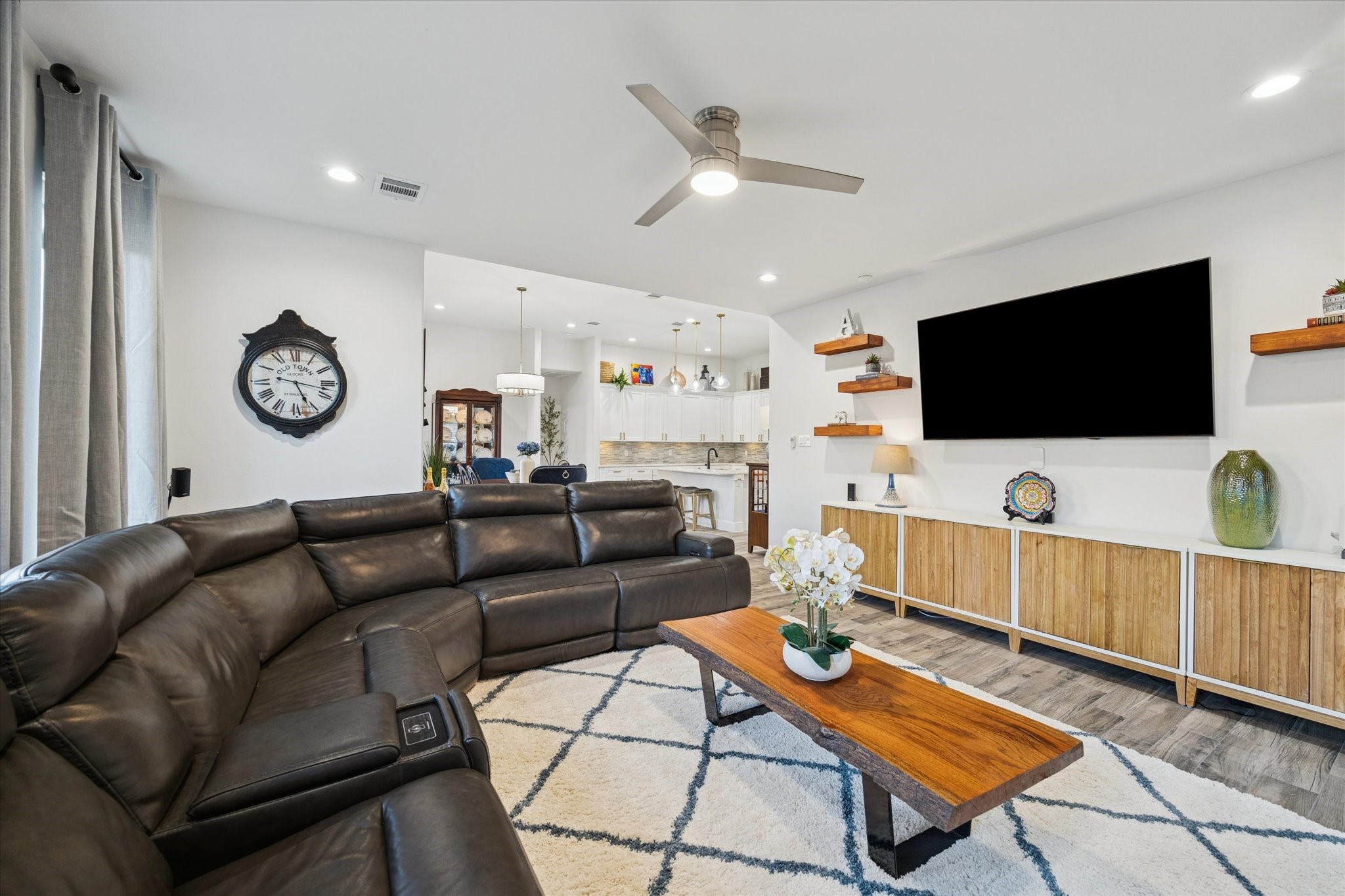 203 Hampton Glen Road Montgomery, TX 77356 - Photo 5 of 28 A spacious and functional open-concept layout designed to stay connected between the living room, kitchen, and breakfast area, while maintaining an open, comfortable flow. Recently installed shelving provides the perfect place to subtly display décor and cherished photos. Abundant natural light fills the area, creating a bright atmosphere while supporting energy efficiency.