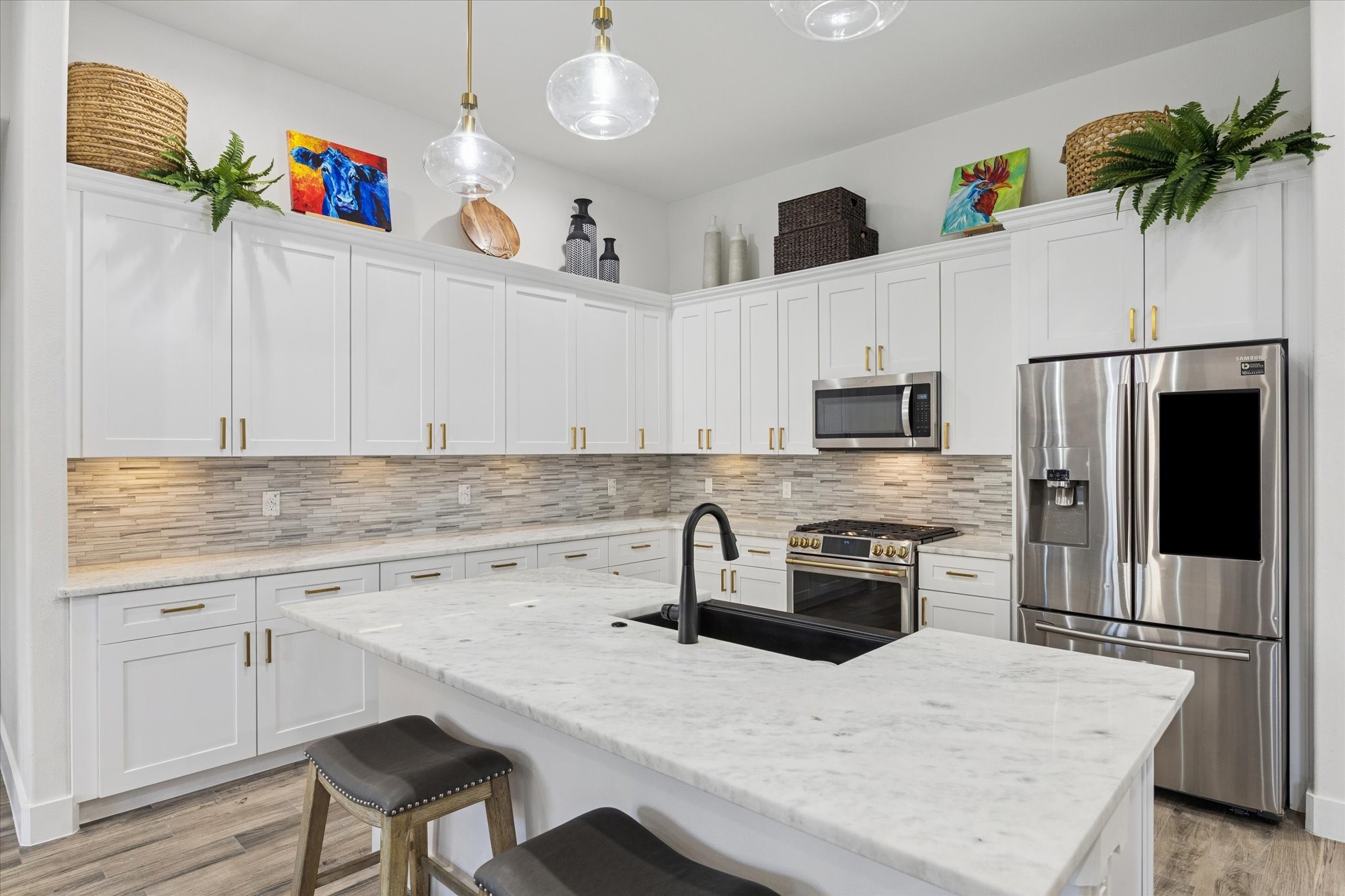 203 Hampton Glen Road Montgomery, TX 77356 - Photo 7 of 28 A dream kitchen with a spacious layout and elegant touches, including marble countertops and new brushed brass pulls on all cabinets. The Cafe Gas Dual Fuel Range with dual ovens and Wi-Fi-enabled oven is perfect for cooking enthusiasts, making meal preparation and entertaining effortless. The harmonious color palette creates a sense of elegance, calm, and inspiration, ideal for cooking, enjoying coffee, and creating memorable moments with family and friends.